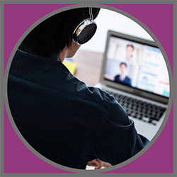 A man wearing a headset and sitting in front of a computer.